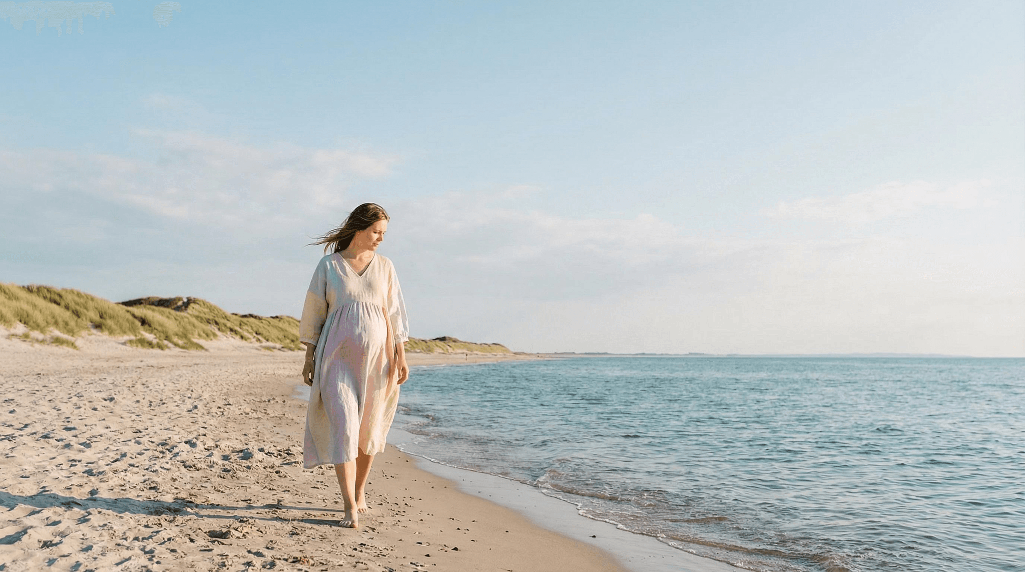 Schwangere Frau spaziert barfuß am Strand entlang – symbolisch für die Frage, welche Mittel in der Schwangerschaft sicher sind und welche Vorsicht erfordern.