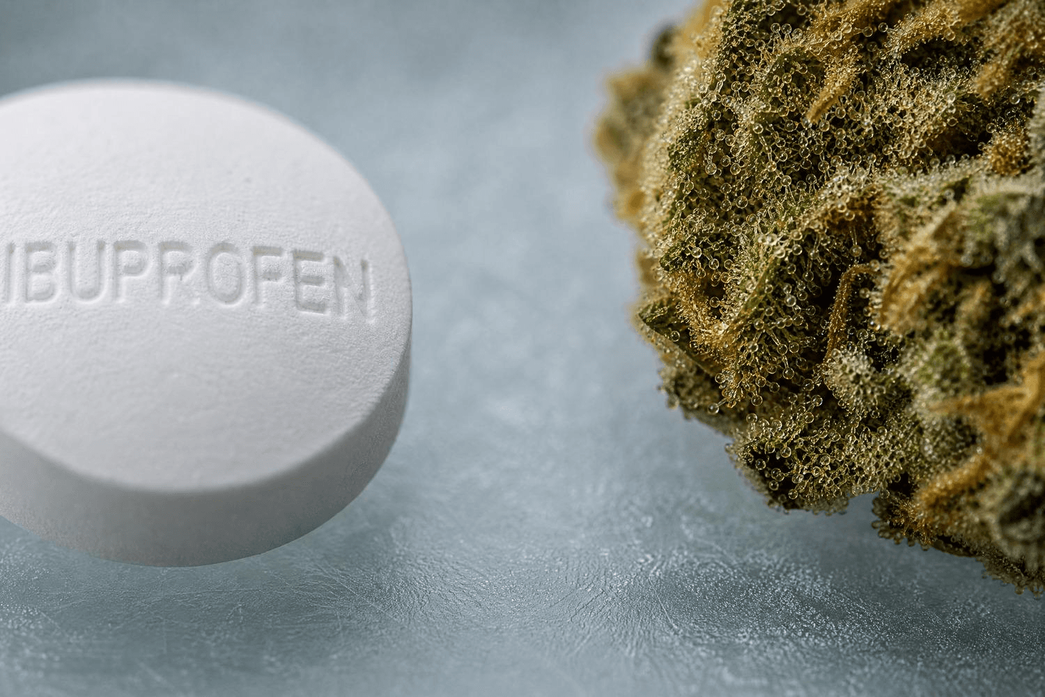 Cannabisblatt neben umgekippter Pillenflasche mit weißen Kapseln