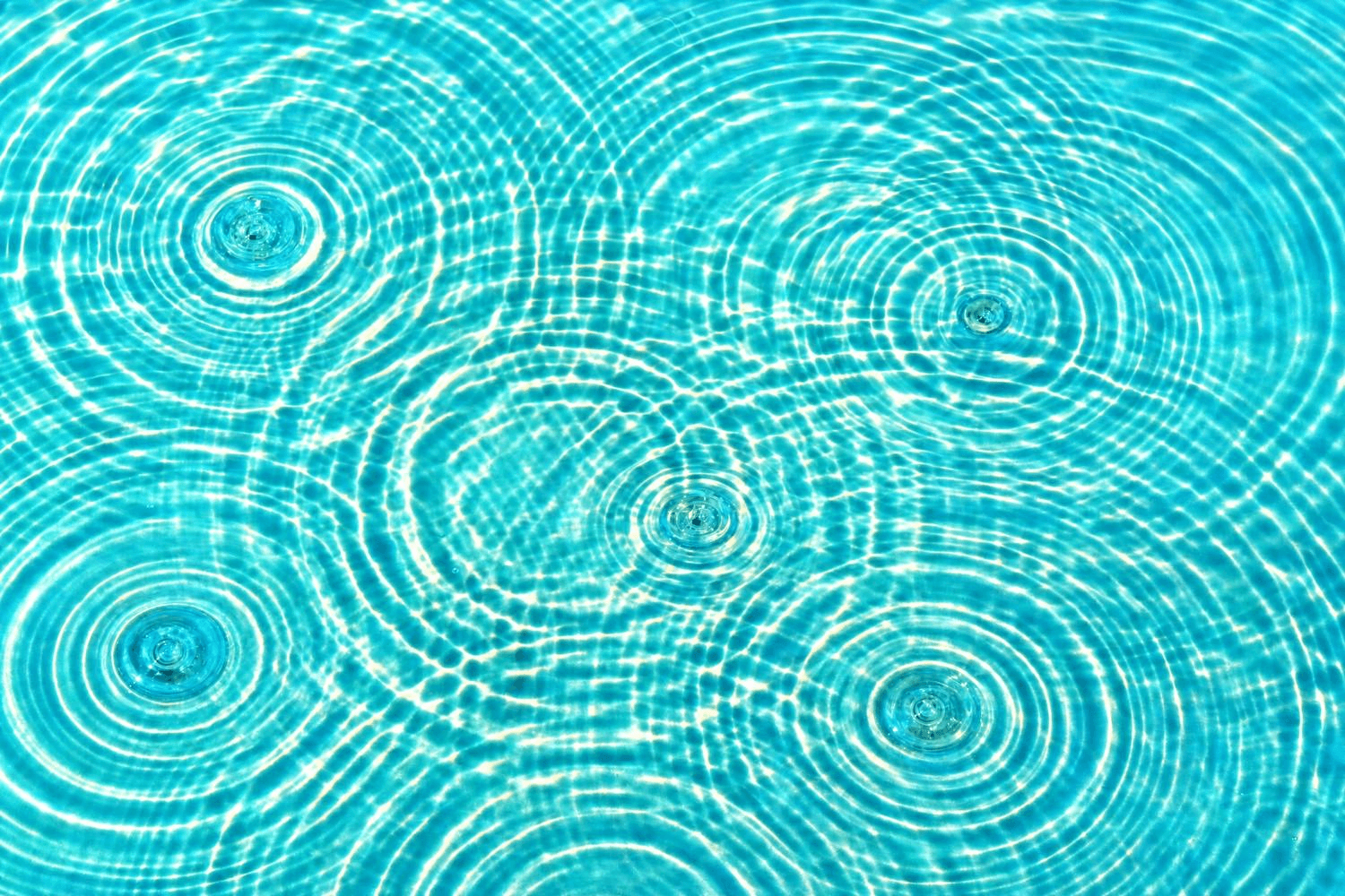 Eine Wasseroberfläche mit fünf sich überlagernden Wellenringen – Metapher für synergistische Effekte