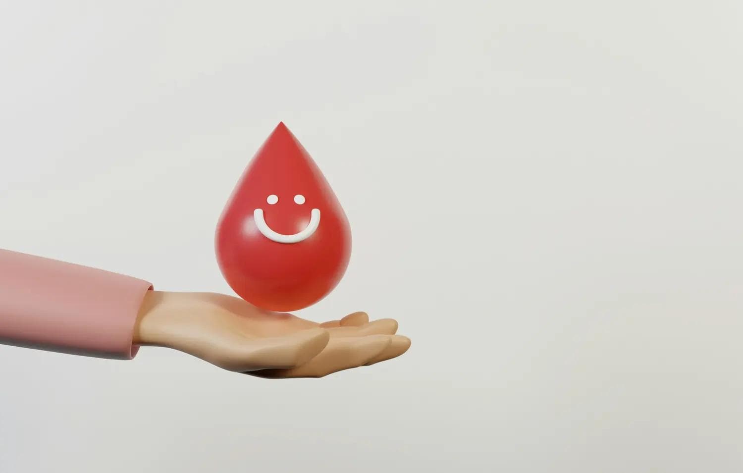 Roter Tropfen mit weißem Smiley über offener Hand