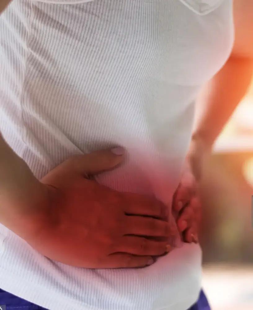 Person hält Hände auf schmerzenden Unterbauch